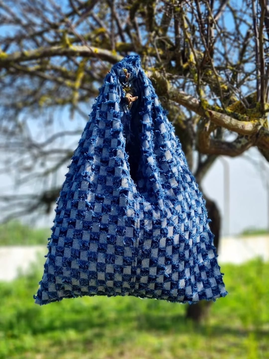 Bolso triangular de tela vaquera entretejida en damero con flecos